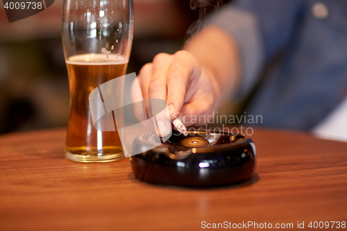 Image of close up of man smoking cigarette at bar