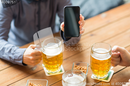 Image of close up of friends with smartphone and beer