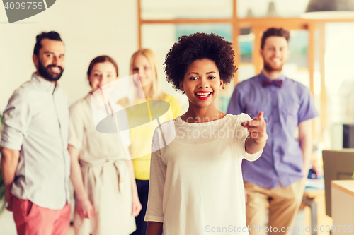Image of woman pointing to you over creative office team