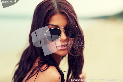 Image of young woman with sunglasses on beach