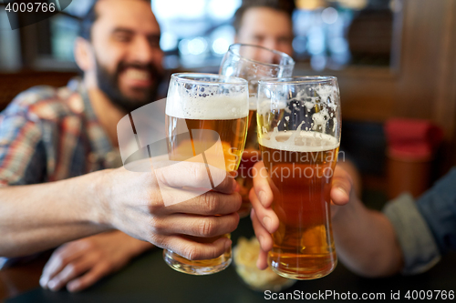 Image of happy male friends drinking beer at bar or pub