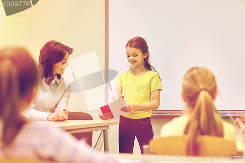 Image of group of school kids with teacher in classroom