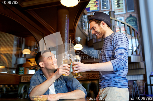 Image of happy male friends drinking beer at bar or pub