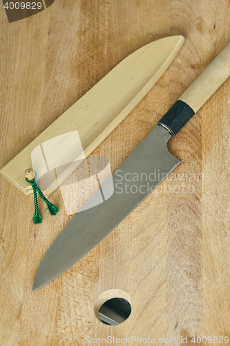 Image of japanese kitchen knife on cutting wooden board