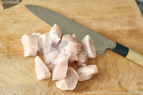 Image of chicken breast chopped up with japanese knife on table