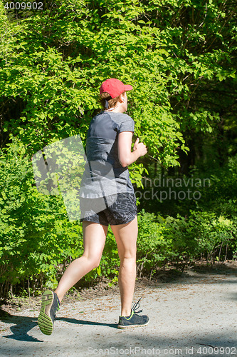 Image of Young female jogger in park