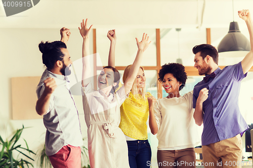 Image of happy creative team celebrating victory in office