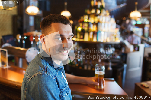 Image of happy man drinking beer at bar or pub