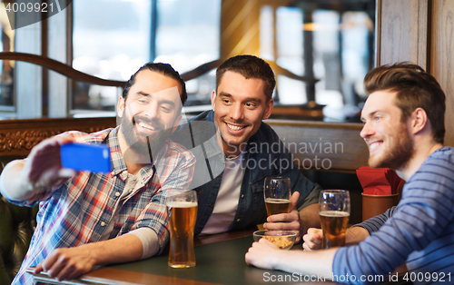 Image of friends taking selfie and drinking beer at bar