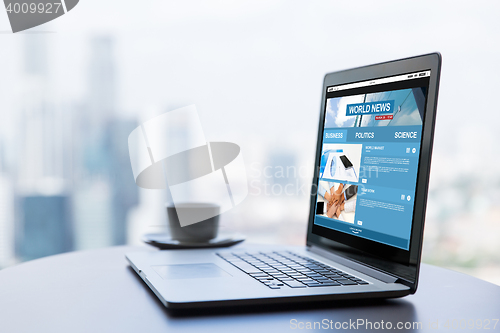 Image of close up of laptop and coffee cup on office table