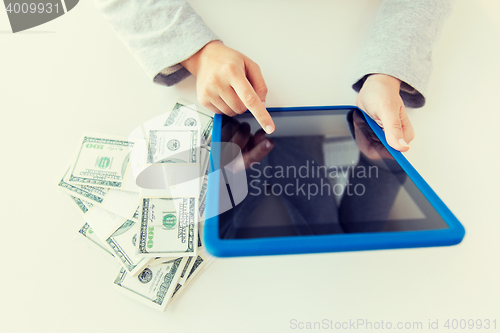 Image of close up of woman hands with tablet pc and money