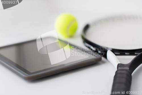 Image of close up of tennis racket with ball and tablet pc