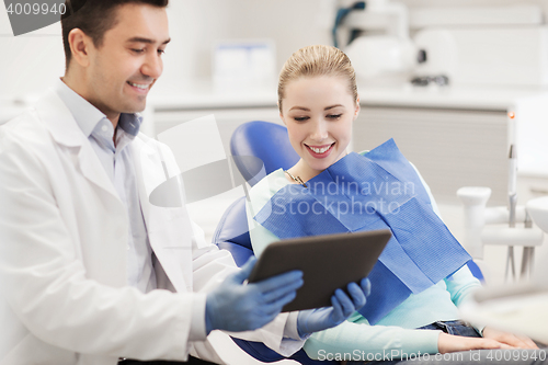 Image of male dentist with tablet pc and woman patient