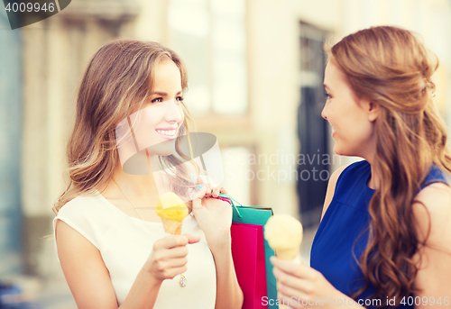 Image of woman with shopping bags and ice cream in city