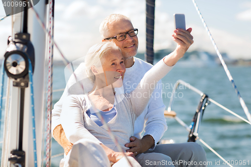 Image of senior couple taking selfie on sail boat or yacht