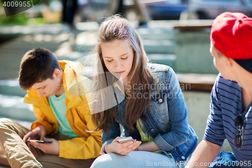 Image of teenage friends with smartphones outdoors