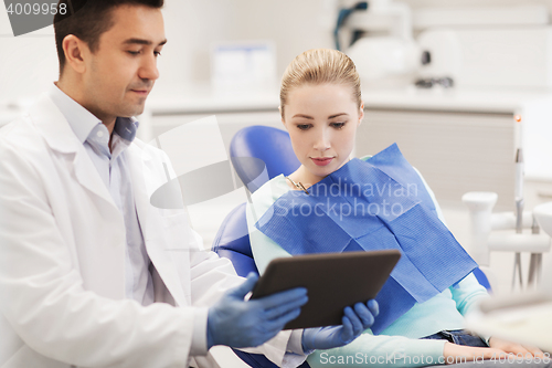 Image of male dentist with tablet pc and woman patient