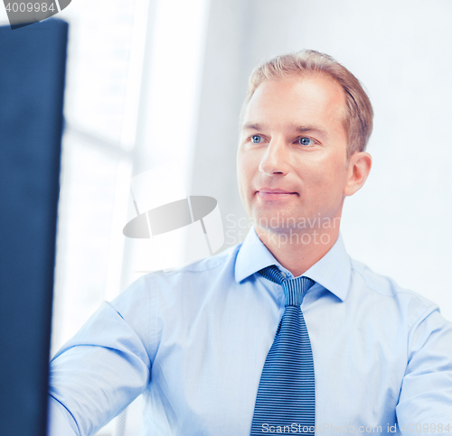 Image of businessman with calculator, computer and papers