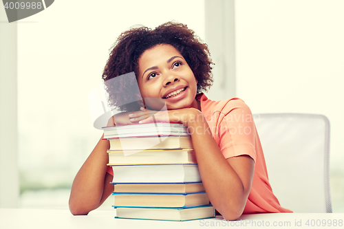 Image of happy african student girl with books at home