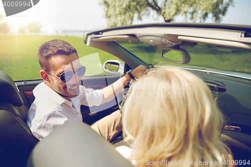 Image of happy man and woman driving in cabriolet car