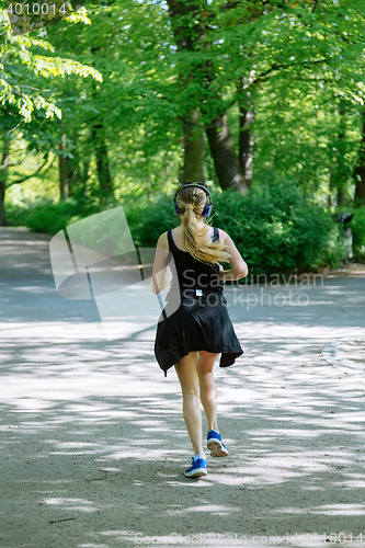 Image of Young female jogger with headphones