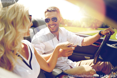 Image of happy man and woman driving in cabriolet car