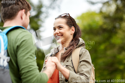 Image of happy couple with backpacks hiking outdoors