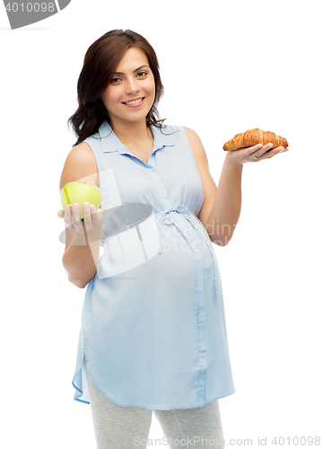 Image of happy pregnant woman with apple and croissant