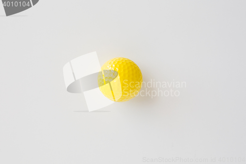 Image of close up of yellow golf ball over white background