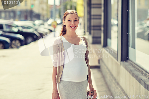 Image of happy smiling pregnant woman at city street