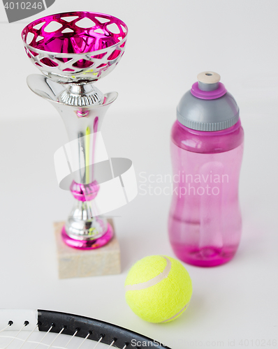 Image of close up of tennis racket, ball, cup and bottle