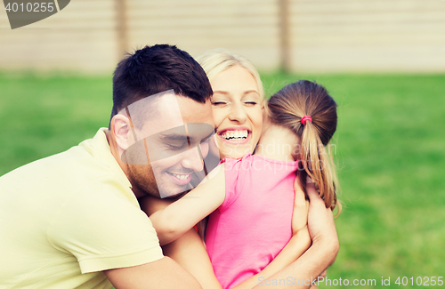 Image of happy family hugging outdoors