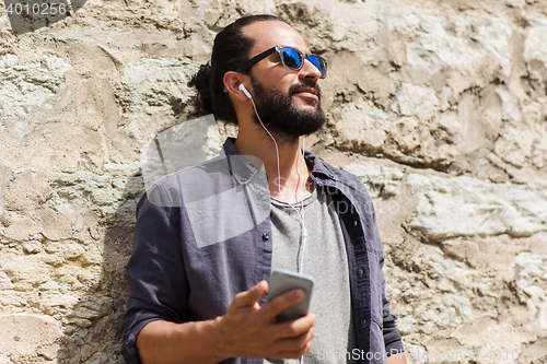 Image of man with earphones and smartphone listening music