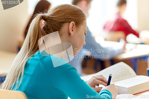 Image of close up of student with book writing school test