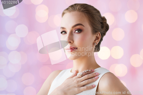 Image of smiling woman in white dress with diamond jewelry