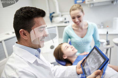 Image of dentist with x-ray on tablet pc and patient girl
