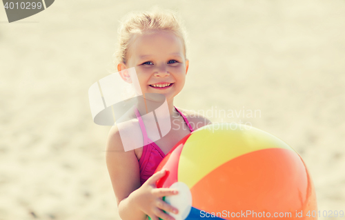 Image of happy little girl playing inflatable ball on beach