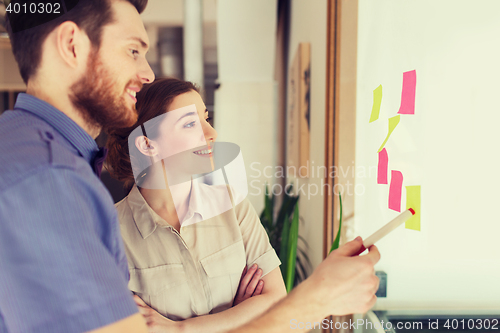 Image of creative team with stickers on glass at office