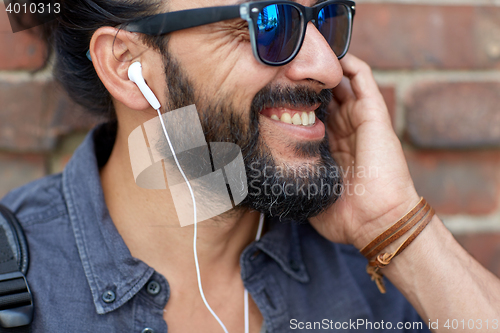 Image of man with earphones listening to music outdoors