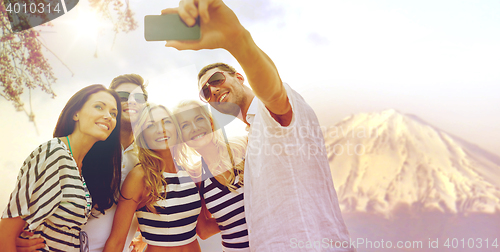 Image of happy friends taking selfie by smartphone in japan