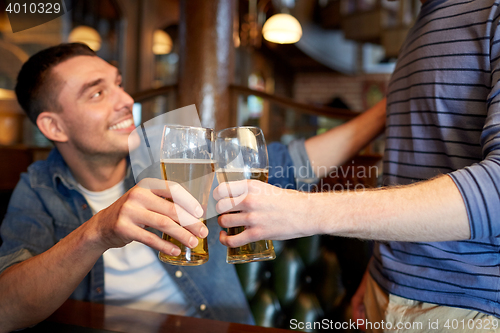 Image of happy male friends drinking beer at bar or pub
