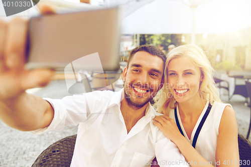 Image of couple taking selfie with smatphone at restaurant