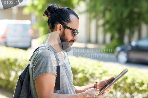 Image of man traveling with backpack and tablet pc in city