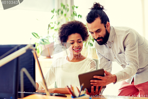 Image of happy creative team with tablet pc in office