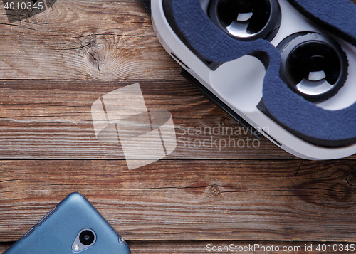 Image of Modern smartphone with empty screen and virtual reality goggles