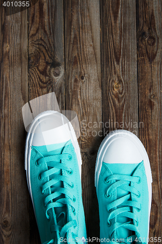 Image of blue sneakers on wooden surface