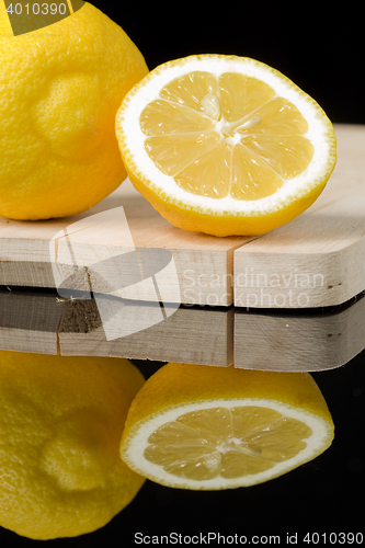 Image of lemon on wood table with black background