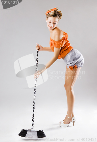 Image of pinup funny young sexy woman sweeping