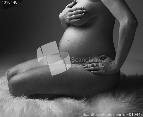 Image of Pregnant Woman holding her hands on beautiful belly