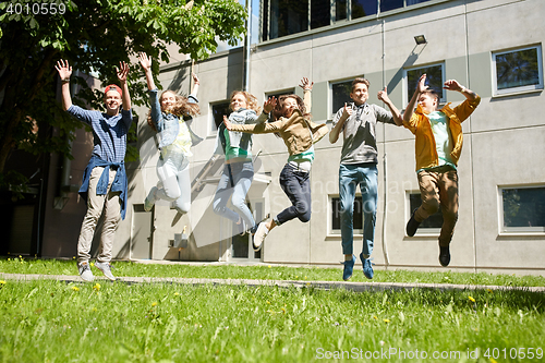 Image of happy teenage students or friends jumping outdoors